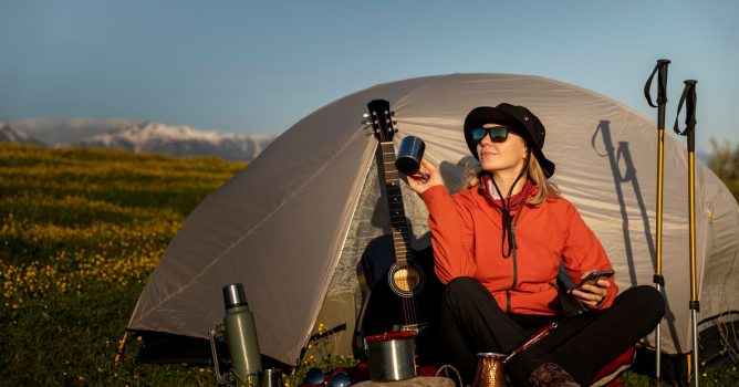 full-shot-smiley-woman-camping-with-tent_52683-88222